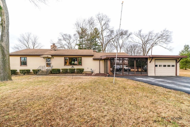 ranch-style home with a garage, a front yard, and a carport