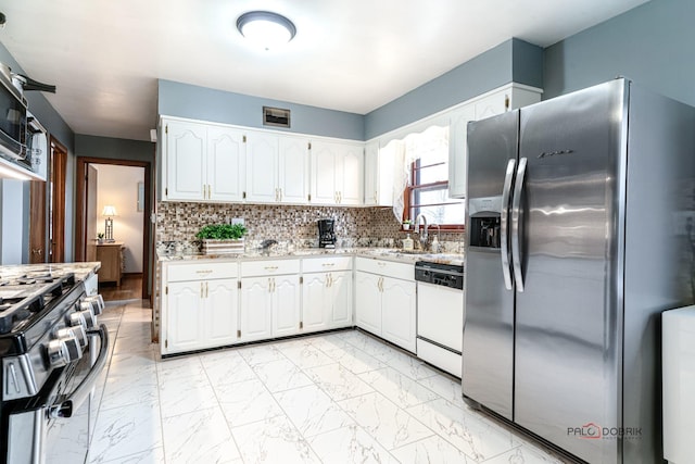 kitchen with white cabinetry, stainless steel appliances, sink, and decorative backsplash