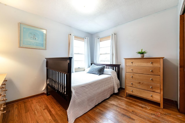 bedroom with wood-type flooring and a textured ceiling