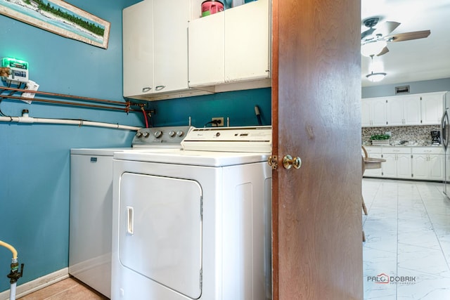 clothes washing area with ceiling fan, cabinets, and washing machine and clothes dryer