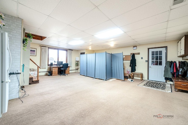 basement with white fridge, carpet flooring, and a drop ceiling