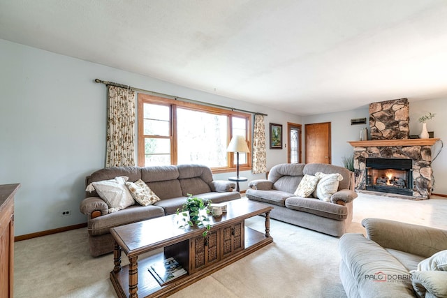 carpeted living room featuring a stone fireplace