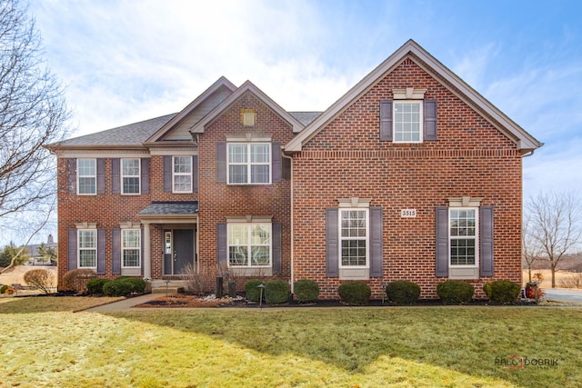 view of front of home with a front lawn and brick siding