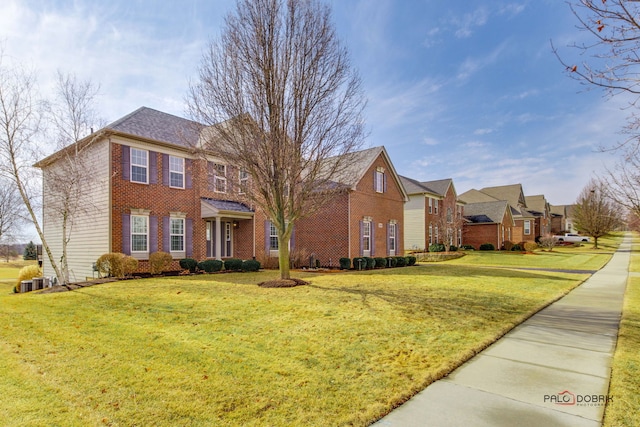 view of front of house featuring a residential view, a front lawn, and brick siding