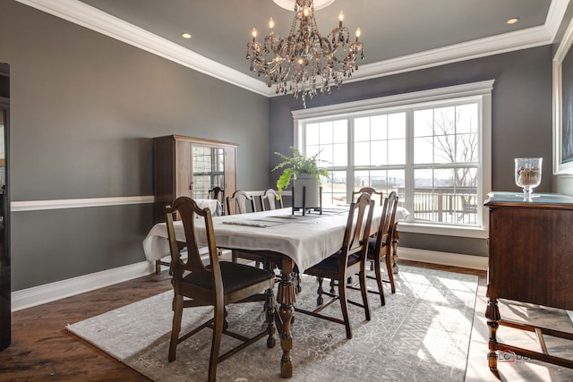 dining area featuring baseboards, a chandelier, wood finished floors, and ornamental molding