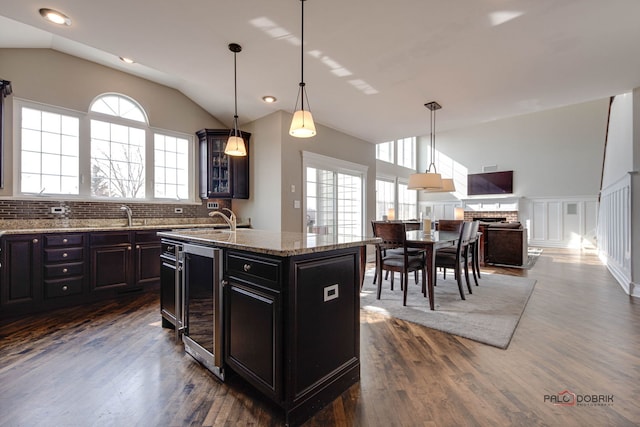 kitchen with beverage cooler, vaulted ceiling, dark wood finished floors, and a wealth of natural light