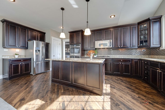 kitchen featuring stainless steel appliances, dark wood-type flooring, dark brown cabinetry, and a center island