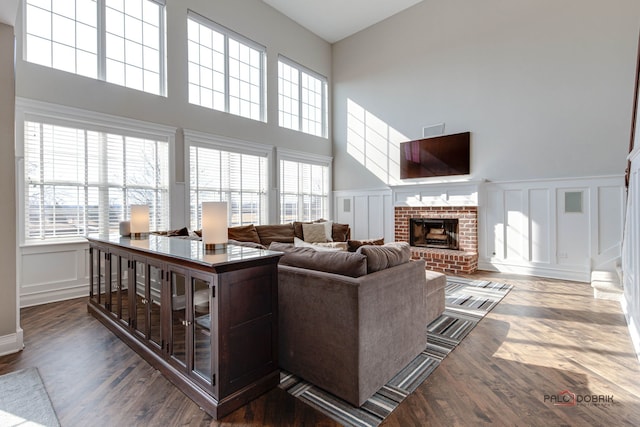 living room with plenty of natural light, a fireplace, and a decorative wall