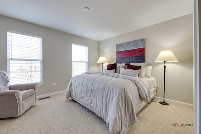 bedroom featuring light carpet, visible vents, and baseboards