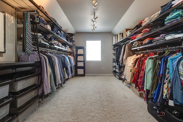 spacious closet with carpet floors and vaulted ceiling