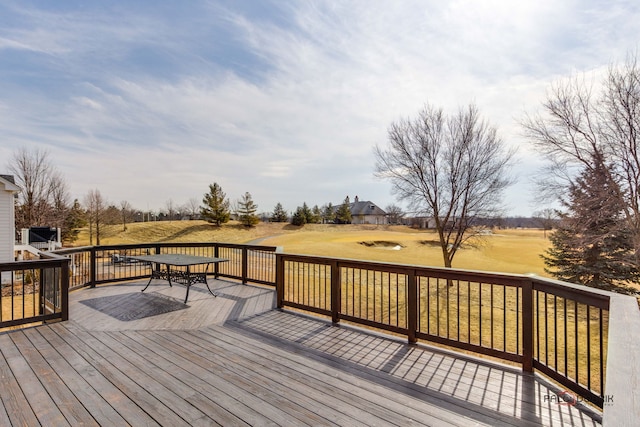 wooden terrace featuring a lawn and outdoor dining space