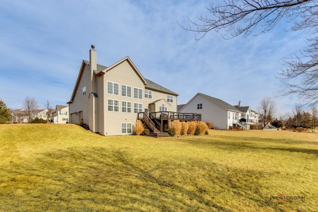 back of house with a deck, a lawn, and a chimney