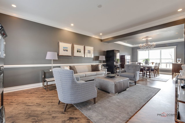 living area with baseboards, ornamental molding, wood finished floors, an inviting chandelier, and recessed lighting