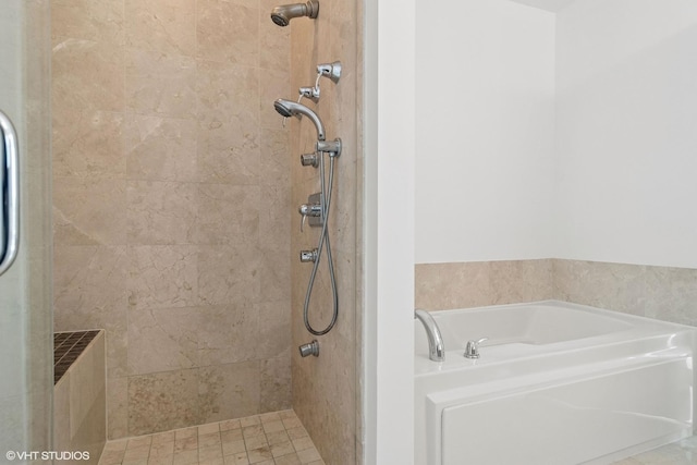 full bath featuring a garden tub and a tile shower