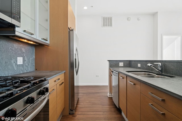 kitchen featuring stainless steel appliances, visible vents, a sink, and decorative backsplash