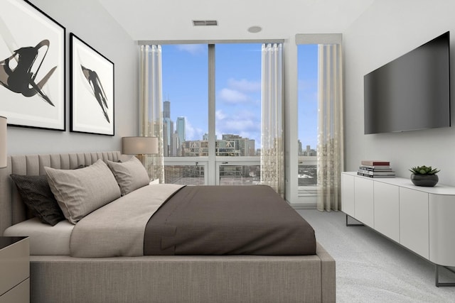 bedroom featuring visible vents, floor to ceiling windows, and light colored carpet