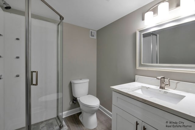 bathroom with toilet, a shower with door, wood-type flooring, and vanity