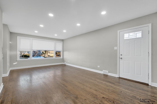 foyer entrance featuring dark hardwood / wood-style floors and a healthy amount of sunlight