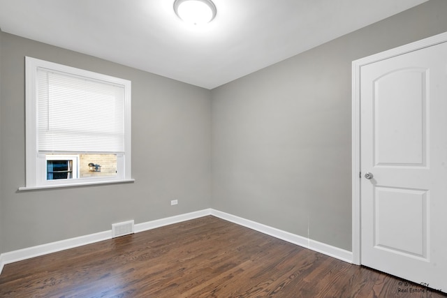 empty room with dark hardwood / wood-style flooring