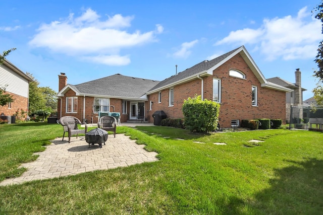 rear view of house featuring an outdoor fire pit, a yard, and a patio area