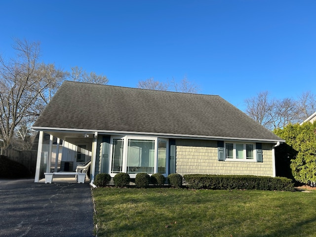 view of front of home with a carport and a front lawn