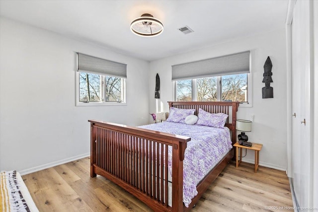 bedroom featuring multiple windows and light hardwood / wood-style flooring