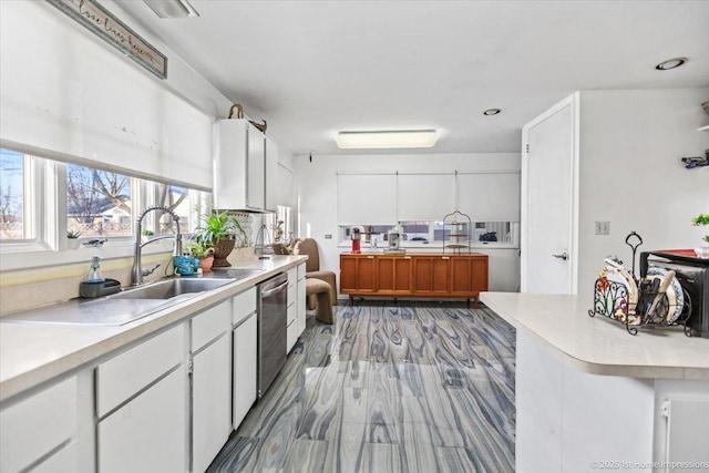 kitchen with sink, stainless steel dishwasher, and white cabinets