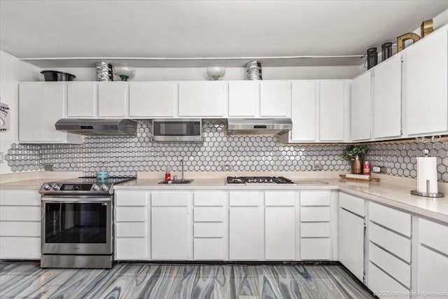 kitchen featuring backsplash, sink, white cabinets, and appliances with stainless steel finishes