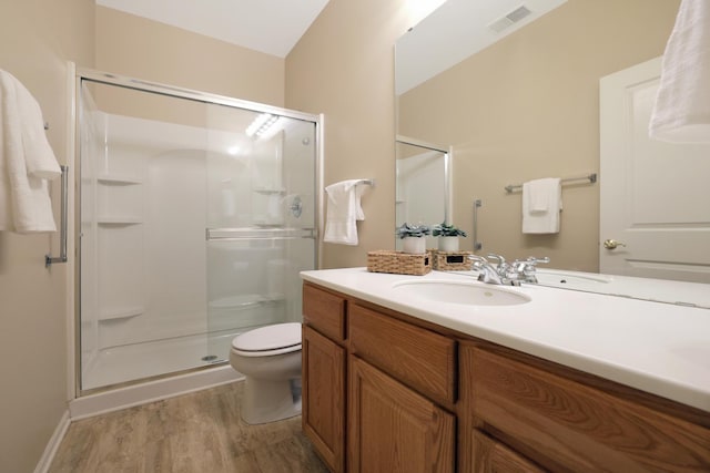 bathroom featuring a shower with shower door, hardwood / wood-style floors, toilet, and vanity