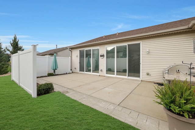 back of house featuring a lawn and a patio