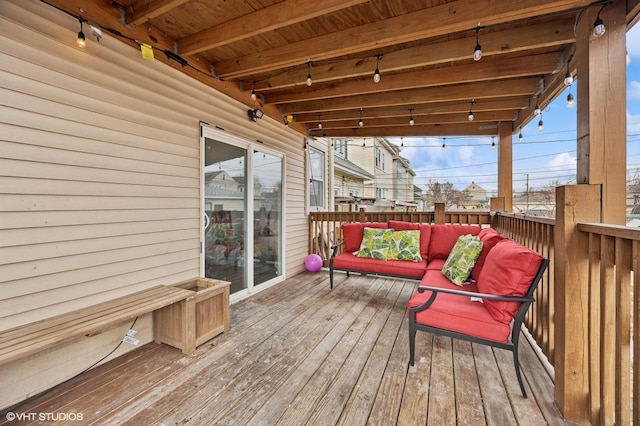 wooden terrace with an outdoor living space