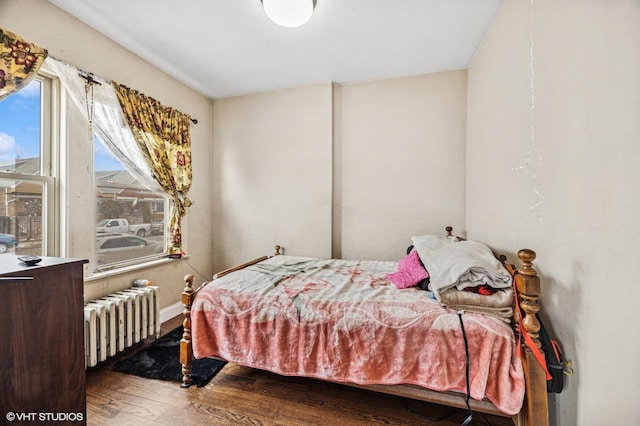 bedroom featuring radiator heating unit and wood-type flooring