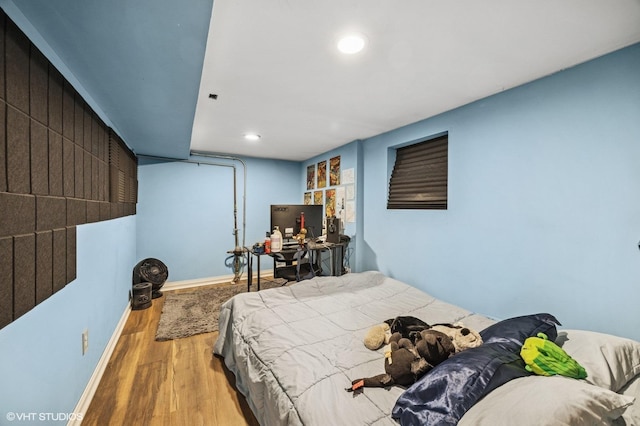 bedroom with baseboards, wood finished floors, and recessed lighting