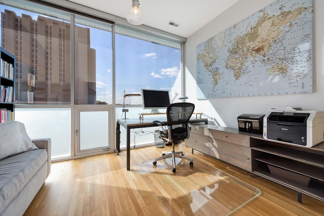 office area with hardwood / wood-style floors and a wall of windows