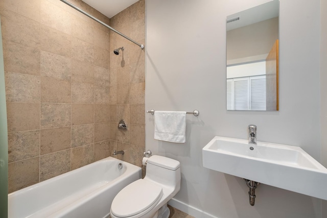 full bathroom with toilet, tiled shower / bath combo, and sink