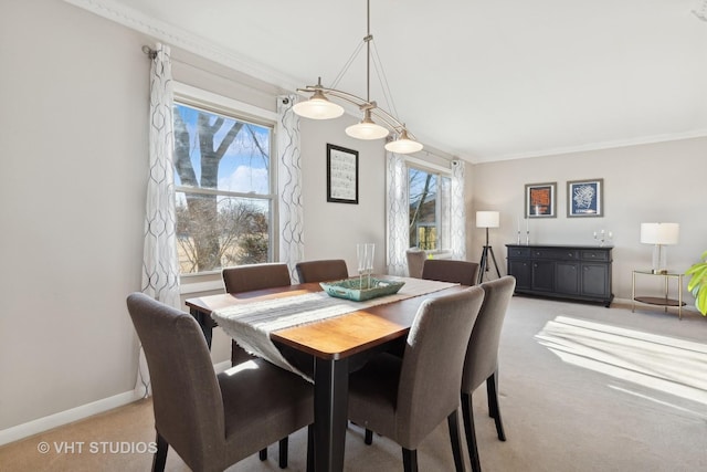 dining space with ornamental molding and light carpet