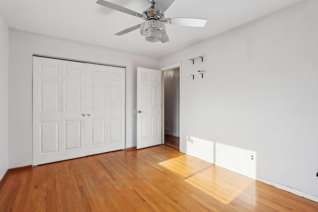 unfurnished bedroom with ceiling fan, hardwood / wood-style floors, and a closet