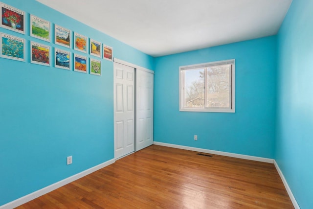 unfurnished bedroom featuring hardwood / wood-style floors and a closet