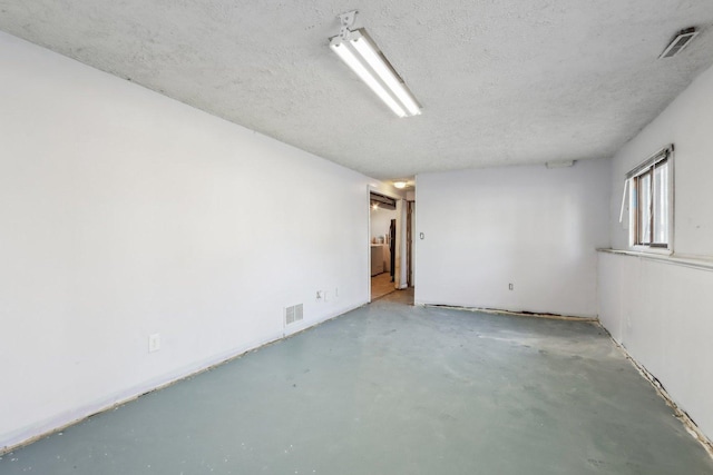 unfurnished room featuring concrete floors and a textured ceiling