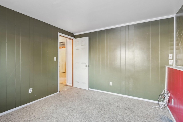 carpeted empty room with wood walls