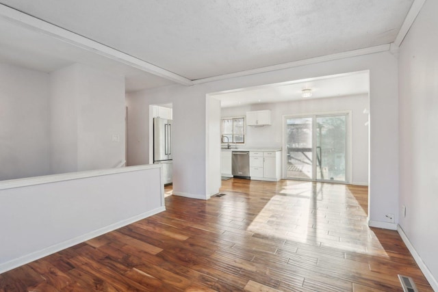 empty room with sink, hardwood / wood-style flooring, and a textured ceiling