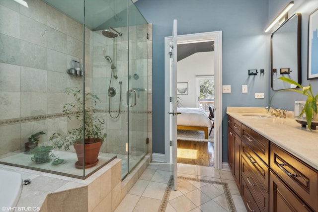 bathroom with a shower with door, tile patterned floors, and vanity