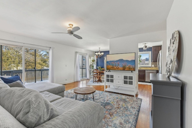 living room featuring hardwood / wood-style flooring and ceiling fan with notable chandelier