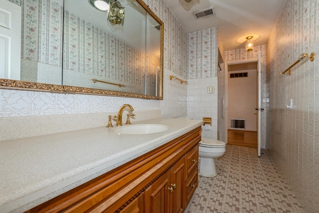 bathroom featuring tile walls, toilet, and vanity