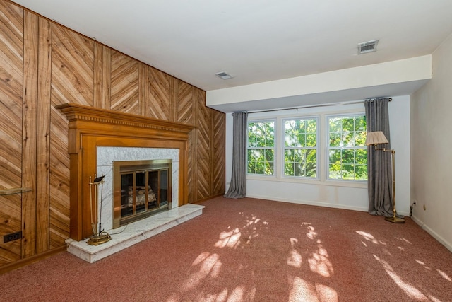 unfurnished living room with wood walls and carpet