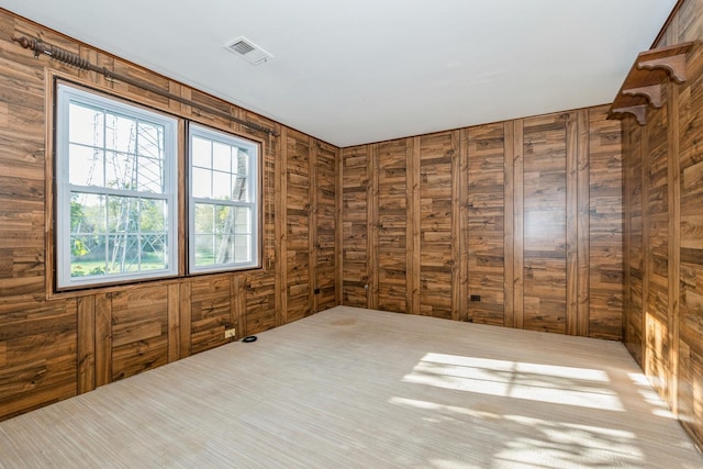 carpeted empty room with wooden walls