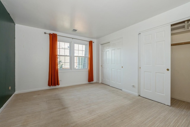 unfurnished bedroom featuring multiple closets