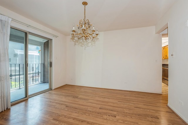 empty room with light hardwood / wood-style flooring and a notable chandelier