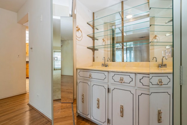 bar featuring sink, white cabinets, and light wood-type flooring