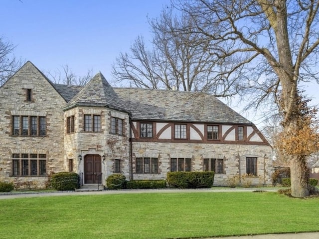 tudor-style house featuring a front yard